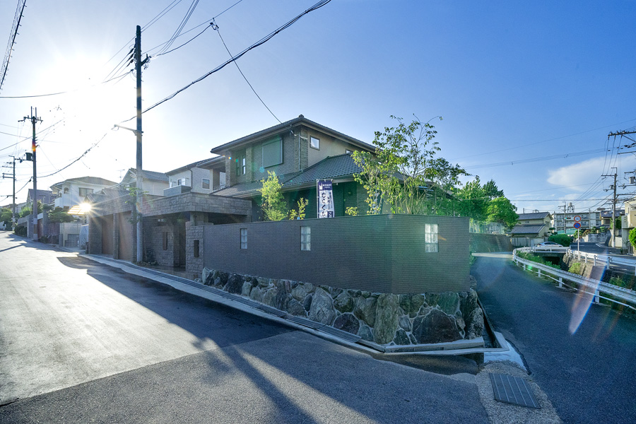 建物全景。既存の植栽をコンパクトにし塀にガラスブロックを配置しています